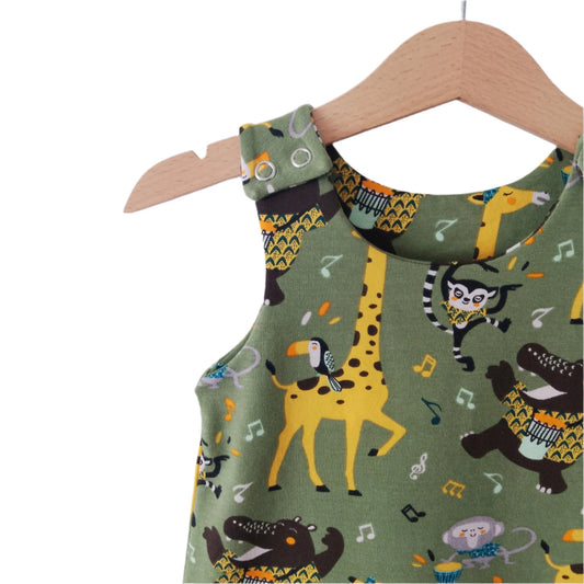 close up detail of shoulder of a green jersey baby romper, featuring safari animals