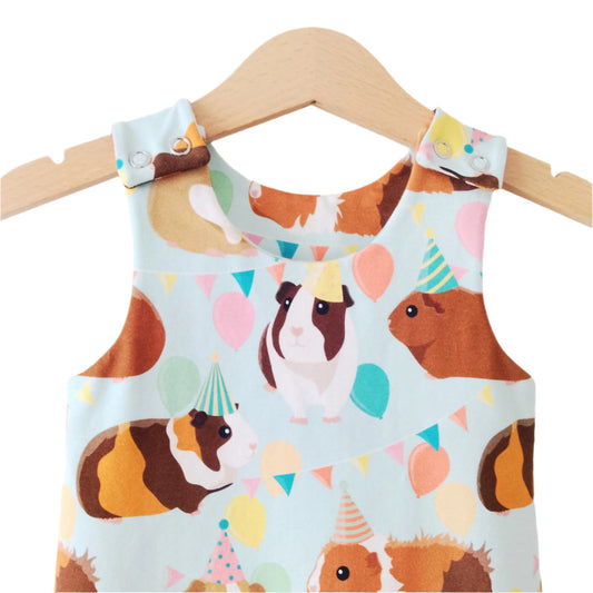 close up detail of jersey baby romper, featuring guinea pigs and party balloons