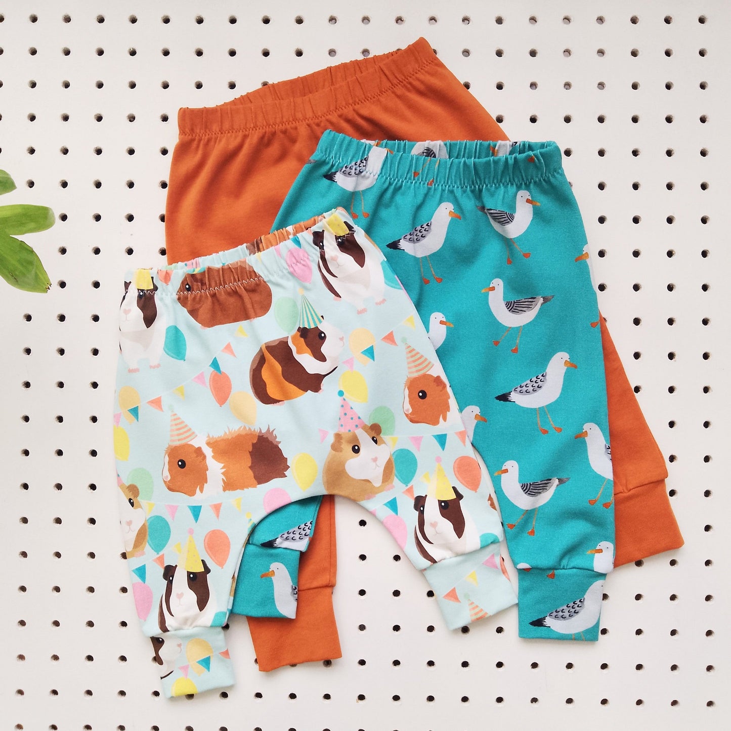 flat lay of a selection of colourful baby harem leggings