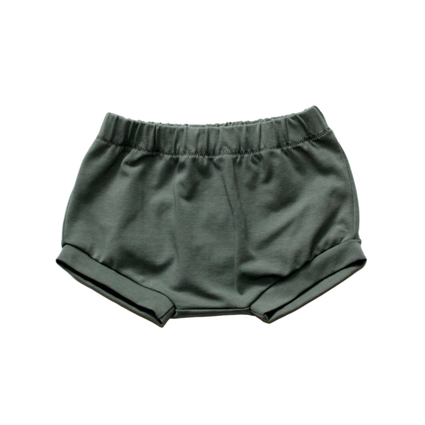 still life of a light khaki pair of baby shorts on a white background