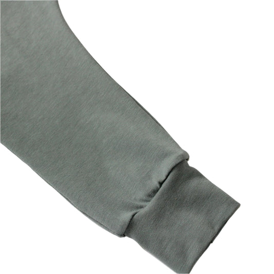 still life of a dusty green baby harem leggings detail, against a white background