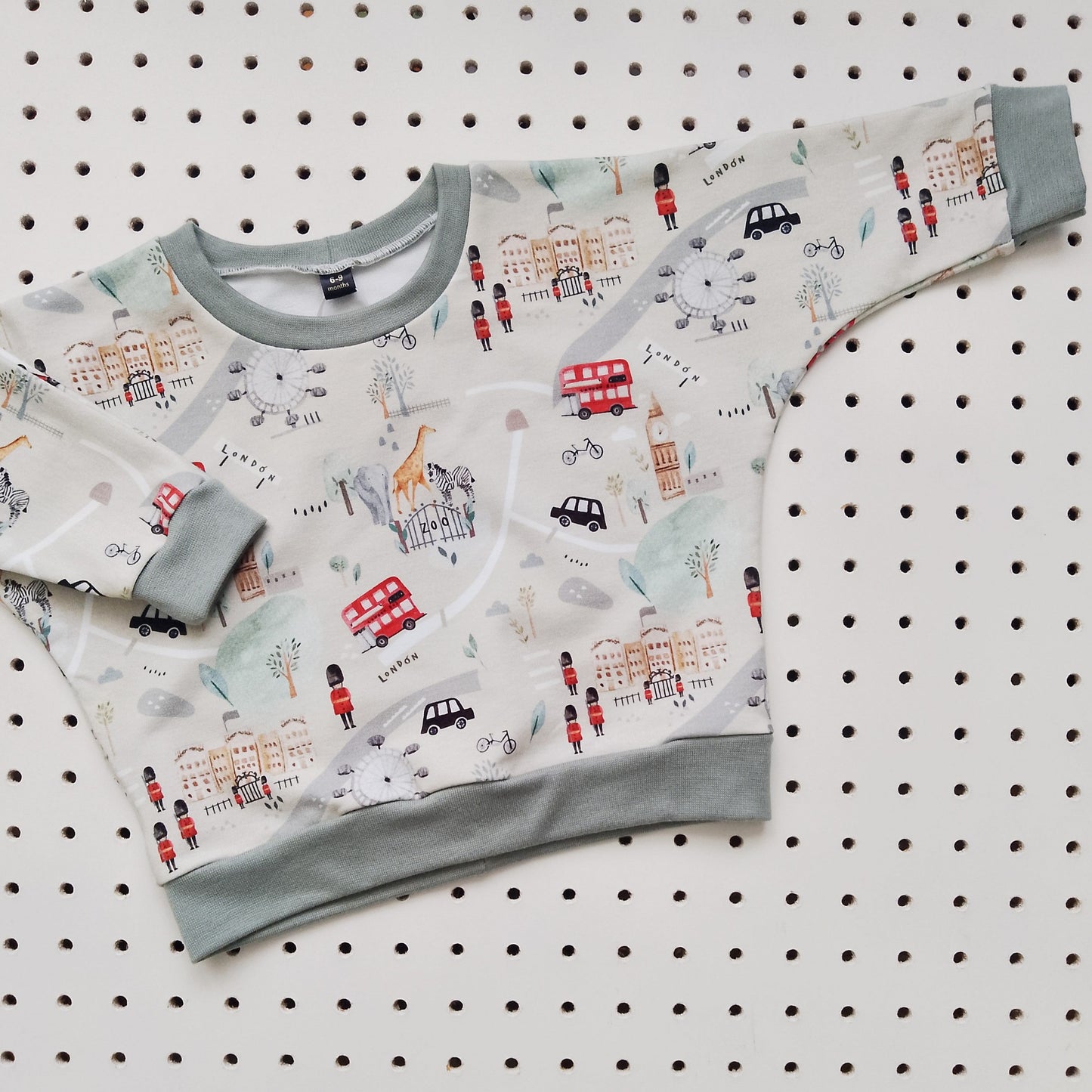 flat lay of beige baby sweatshirt, featuring london tourist icons